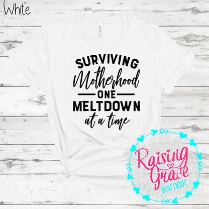 Surviving Motherhood One Meltdown At A Time Graphic T-Shirt | Funny Mom Tee | Boutique Mama Shirt | Relatable Mom Graphic Tee | Motherhood Shirt